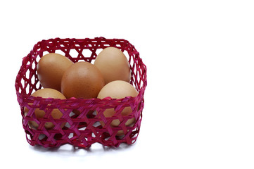 A group of eggs in the red bamboo basket on the white background
