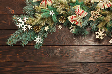 fir branches with Christmas decor on old dark wooden background