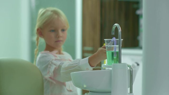 Pretty girl picks up water with saliva ejector