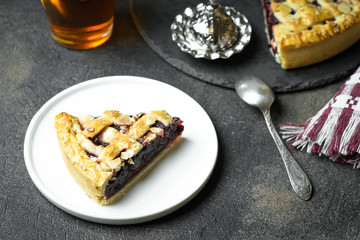 Piece of Delicious Homemade Cherry Pie with a Flaky Crust on dark background