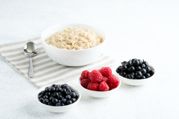 Oatmeal with berries and fruits on a light background. Healthy breakfast.
