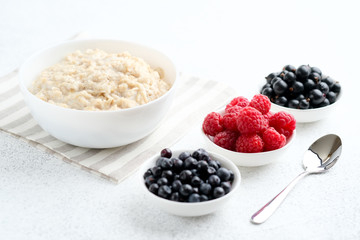 Oatmeal with berries and fruits on a light background. Healthy breakfast.