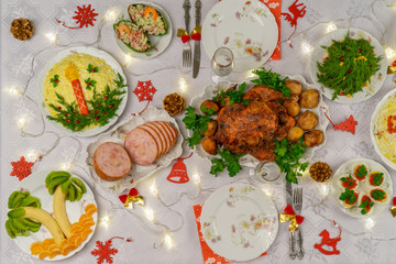 Festive Christmas served table with delicious food and decorative items. Dinner for New Year party, Christmas turkey. Winter holiday celebration at cozy home. Top view