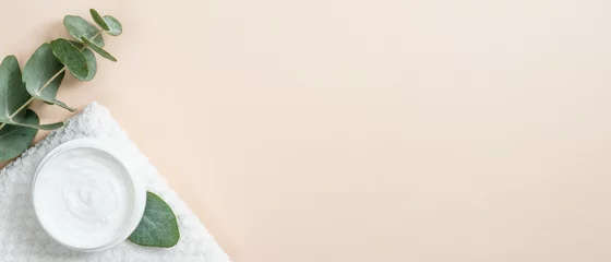 Zelfklevend Fotobehang Pot biologische crème met eucalyptus bladeren op beige achtergrond. Plat lag, bovenaanzicht, kopieer ruimte. Natuurlijk biologisch product, schoonheids- en spa-concept © photoguns