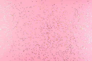 Golden confetti stars scattered a pink pastel background.