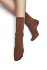 Cropped shot of a girl's foots, lying on a white background. It is brown socks on her foots. 