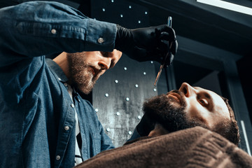 YOUNG HANDSOME BEARDED MAN IN BARBERSHOP