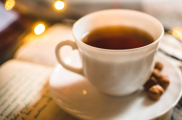 Hot black tea in an irony and warm atmosphere with a garland, Christmas atmosphere, morning lighting