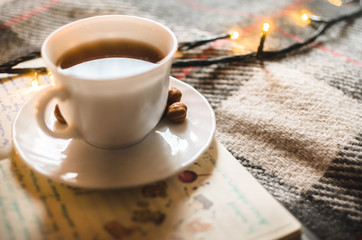Hot black tea in an irony and warm atmosphere with a garland, Christmas atmosphere, morning lighting
