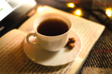 Hot black tea in an irony and warm atmosphere with a garland, a cold winter night and a Christmas atmosphere