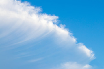 The sky is bright and the clouds are arranged in a diagonal direction, like waves intersecting with the sky. During the daytime.