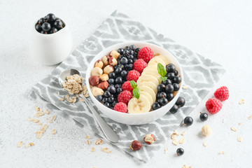 Healthy breakfast. Oatmeal with berries and fruits and milk on a light background copy space.