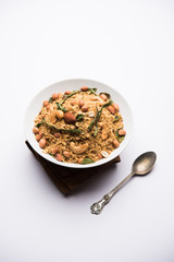 Oats Chivda / Chiwda is a healthy indian recipe with added chilli, peanuts, cashew, almond and curry leaf for flavour. Selective focus