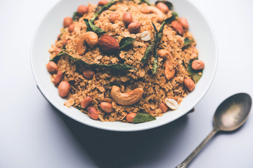 Oats Chivda / Chiwda is a healthy indian recipe with added chilli, peanuts, cashew, almond and curry leaf for flavour. Selective focus