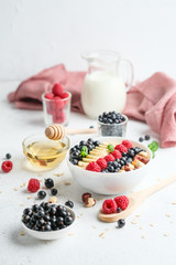 Healthy breakfast. Oatmeal with berries and fruits and milk on a light background copy space.