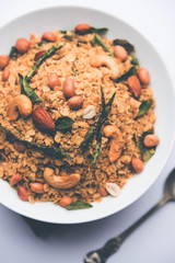 Oats Chivda / Chiwda is a healthy indian recipe with added chilli, peanuts, cashew, almond and curry leaf for flavour. Selective focus