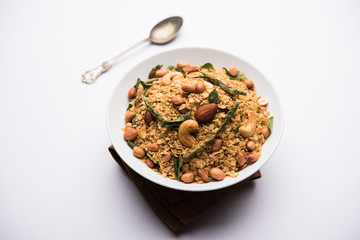 Oats Chivda / Chiwda is a healthy indian recipe with added chilli, peanuts, cashew, almond and curry leaf for flavour. Selective focus