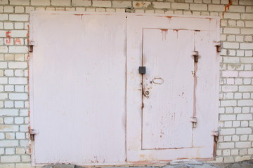 Painted rose color metal garage door with brich wall