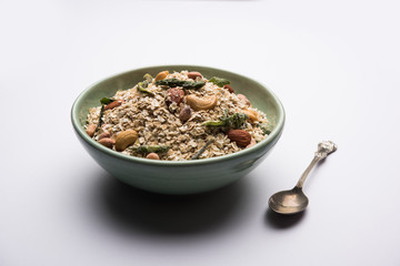 Oats Chivda / Chiwda is a healthy indian recipe with added chilli, peanuts, cashew, almond and curry leaf for flavour. Selective focus