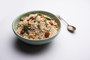 Oats Chivda / Chiwda is a healthy indian recipe with added chilli, peanuts, cashew, almond and curry leaf for flavour. Selective focus
