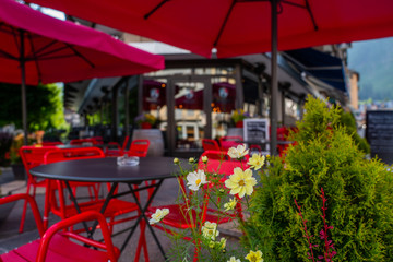 Cozy street with tables of cafe old town street in Chamonix village, France. Architecture and landmark. Cozy cityscape. Typical view of the street with tables of cafe in Chamonix.