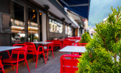Cozy street with tables of cafe old town street in Chamonix village, France. Architecture and landmark. Cozy cityscape. Typical view of the street with tables of cafe in Chamonix.