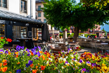 Cozy street with tables of cafe old town street in Chamonix village, France. Architecture and landmark. Cozy cityscape. Typical view of the street with tables of cafe in Chamonix.