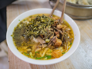 Close uo Chinese Chinese traditional noodle topping with Pickles and pork in chinese breakfast restaurant