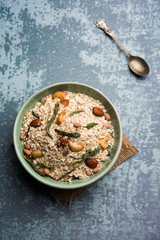 Oats Chivda / Chiwda is a healthy indian recipe with added chilli, peanuts, cashew, almond and curry leaf for flavour. Selective focus