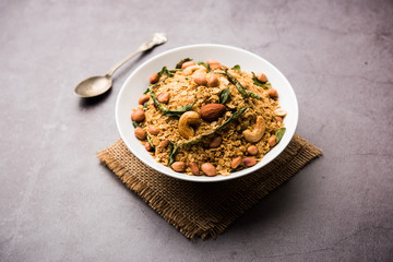 Oats Chivda / Chiwda is a healthy indian recipe with added chilli, peanuts, cashew, almond and curry leaf for flavour. Selective focus
