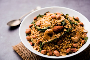 Oats Chivda / Chiwda is a healthy indian recipe with added chilli, peanuts, cashew, almond and curry leaf for flavour. Selective focus