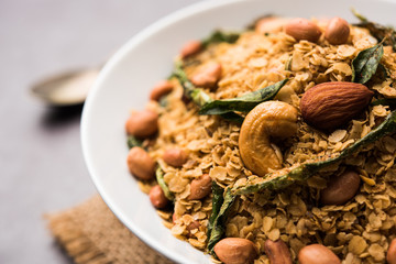Oats Chivda / Chiwda is a healthy indian recipe with added chilli, peanuts, cashew, almond and curry leaf for flavour. Selective focus