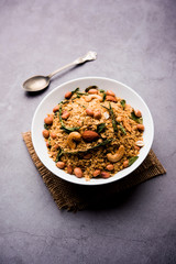 Oats Chivda / Chiwda is a healthy indian recipe with added chilli, peanuts, cashew, almond and curry leaf for flavour. Selective focus