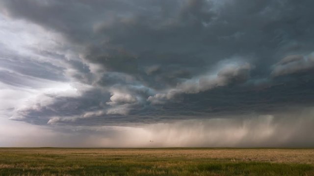 Clouds moving in time lapse bringing dramatic storm as it moves over the plains.