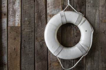 Life ring on a rustic wood wall with copy space.