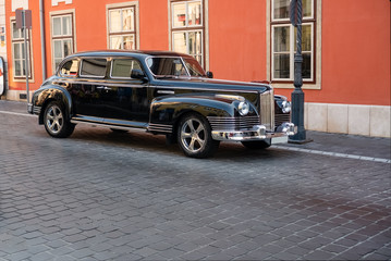 Soviet limousine ZIS-110 parking on a cobblestone street