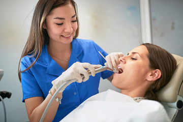Obraz na płótnie Canvas Young woman during the dental procedure with dentist