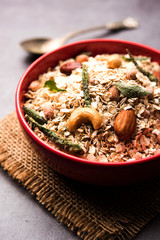 Oats Chivda / Chiwda is a healthy indian recipe with added chilli, peanuts, cashew, almond and curry leaf for flavour. Selective focus