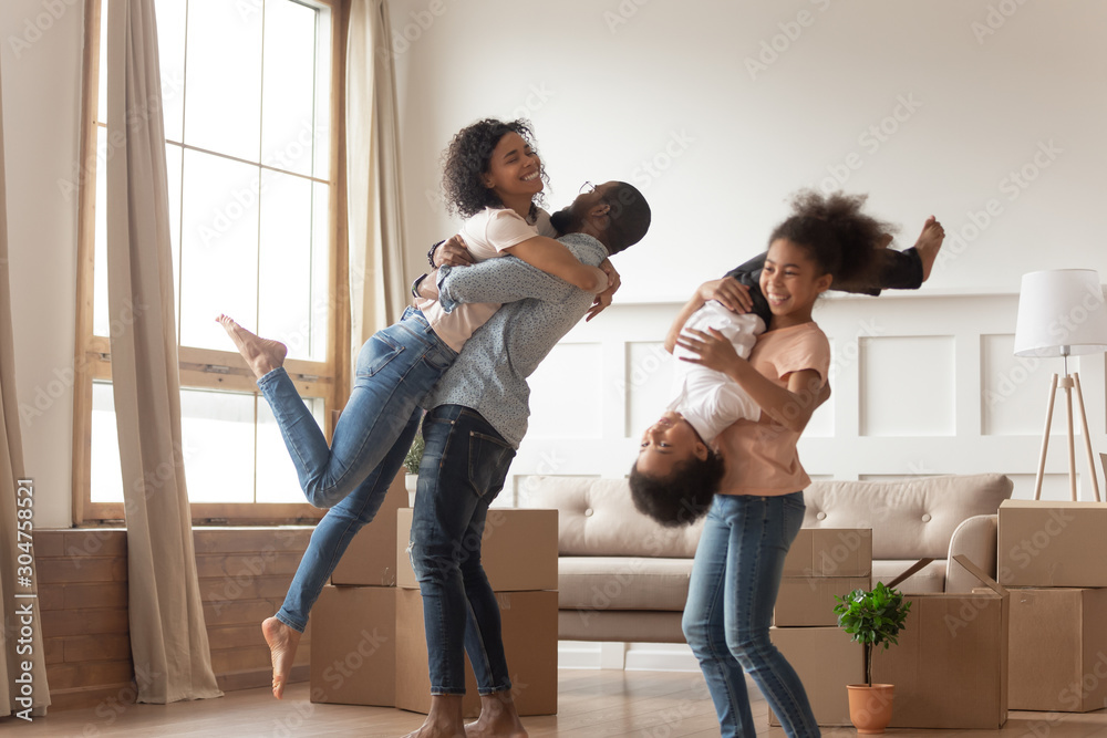 Wall mural African family have fun in living room celebrating relocation day