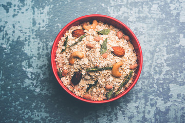 Oats Chivda / Chiwda is a healthy indian recipe with added chilli, peanuts, cashew, almond and curry leaf for flavour. Selective focus