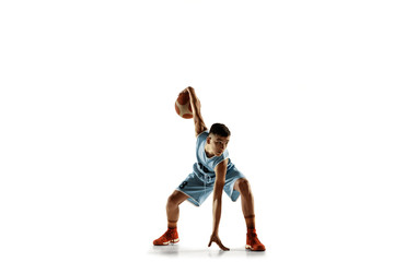 Full length portrait of young basketball player with a ball isolated on white studio background. Teenager training and practicing in action, motion. Concept of sport, movement, healthy lifestyle, ad.