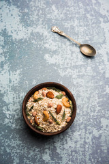 Oats Chivda / Chiwda is a healthy indian recipe with added chilli, peanuts, cashew, almond and curry leaf for flavour. Selective focus