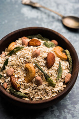 Oats Chivda / Chiwda is a healthy indian recipe with added chilli, peanuts, cashew, almond and curry leaf for flavour. Selective focus