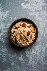 Oats Chivda / Chiwda is a healthy indian recipe with added chilli, peanuts, cashew, almond and curry leaf for flavour. Selective focus