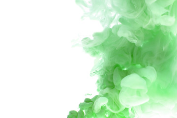 Abstract flowing liquid or green ink in water on a white background. It looks like smoke or cloud....