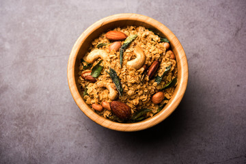 Oats Chivda / Chiwda is a healthy indian recipe with added chilli, peanuts, cashew, almond and curry leaf for flavour. Selective focus