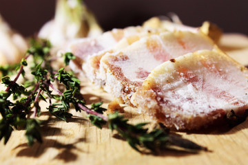 Sliced ​​pieces of bacon on a wooden table close-up