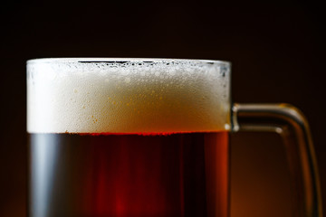 Dark Beer Mug with White Foam on Dark Background Close Up