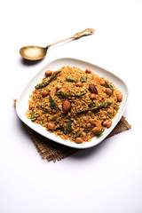 Oats Chivda / Chiwda is a healthy indian recipe with added chilli, peanuts, cashew, almond and curry leaf for flavour. Selective focus