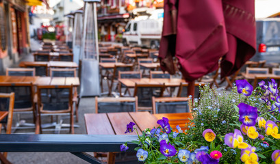 Cozy street with tables of cafe old town street in Chamonix village, France. Architecture and landmark. Cozy cityscape. Typical view of the street with tables of cafe in Chamonix.